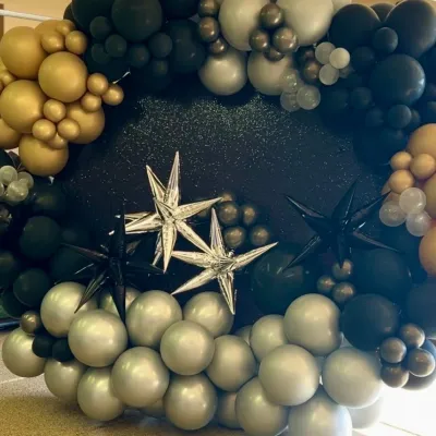 Balloon backdrop with black, gold, silver and spiky shaped balloons