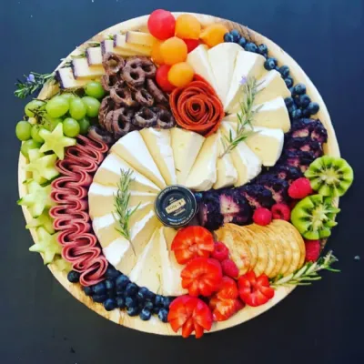 Shelf lined with presents and a pink, white, blue, orange and flower balloon arch