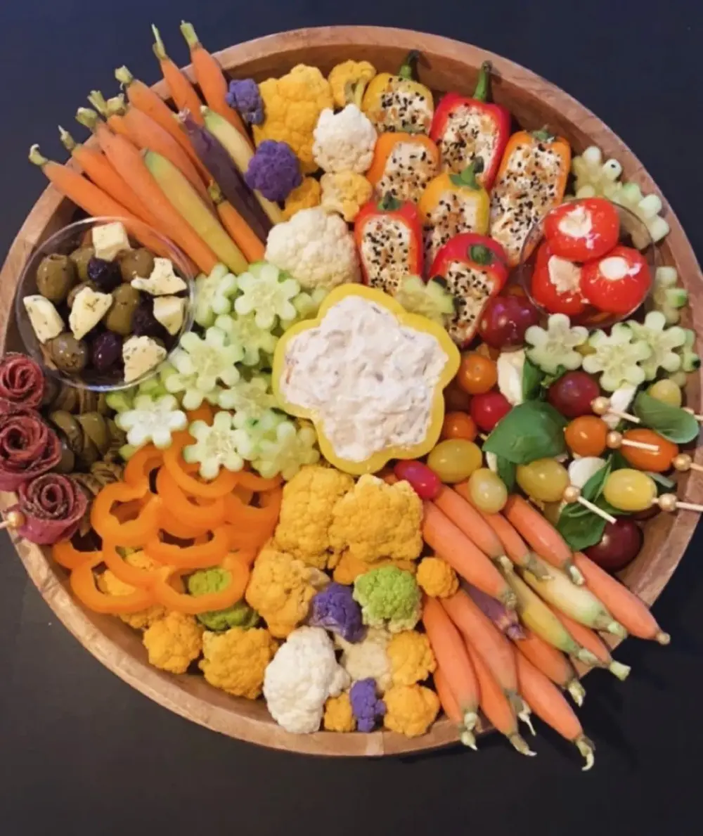 Artfully arranged charcuterie board with bell peppers filled with dip