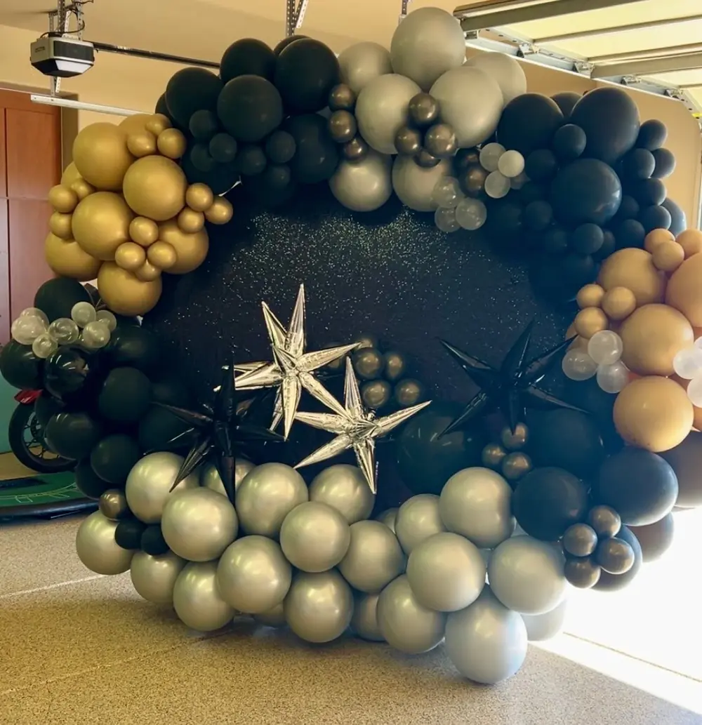 Gold black and silver balloon display with backdrop